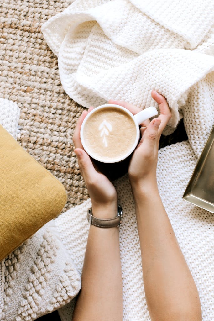 Crop faceless woman holding cup of cappuccino
